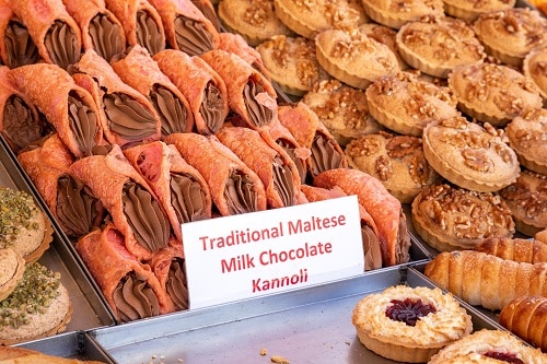 traditional maltese milk chocolate kannolis and other malta treats on display at a bakery in malta