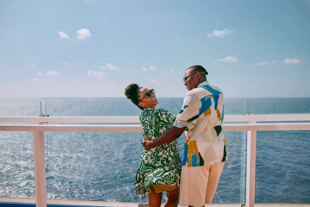 couple laughing and looking over the rail of a carnival cruise ship